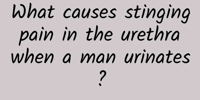 What causes stinging pain in the urethra when a man urinates?